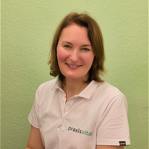 Eine lächelnde Frau mit braunen Haaren trägt ein weißes Poloshirt vor grünem Hintergrund